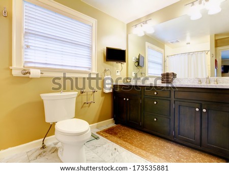 Modern bathroom with black wood cabinets, big mirror and tv