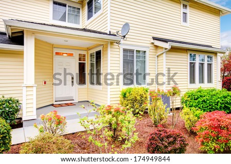 Two story siding house with small porch and front flowerbed