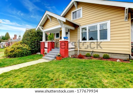 Clapboard siding house . Porch with brick base columns and stairs