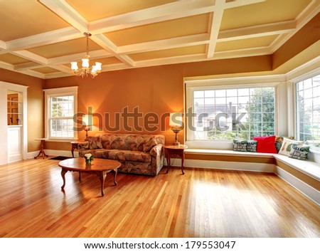 Living room with a coffered ceiling and hardwood floor. Furnished with an antique sofa, coffee table.