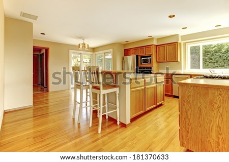 Bright kitchen room with windows. View of cabinets and counter stools and walkout deck. View of cabinets and counter stools