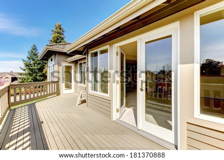 Siding house with spacious walkout deck. View of open white door