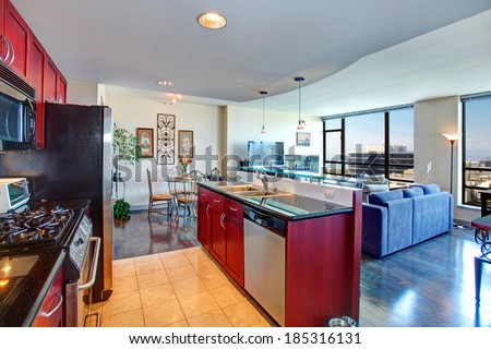 Modern apartment interior. Black and burgundy kitchen, bright living room with glass wall and old fashioned dining area