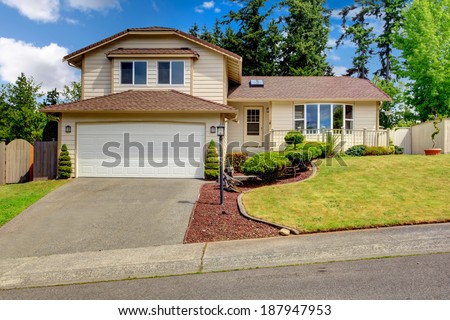 Clapboard siding house with tile roof. House has deck and garage.
