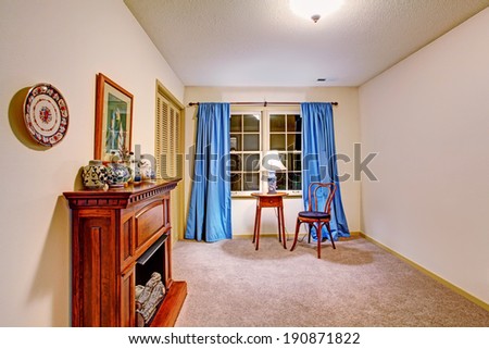 Small room with french window, antique table and chair and fake fireplace