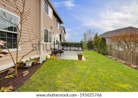 House with backyard walkout deck, small patio area and green lawn