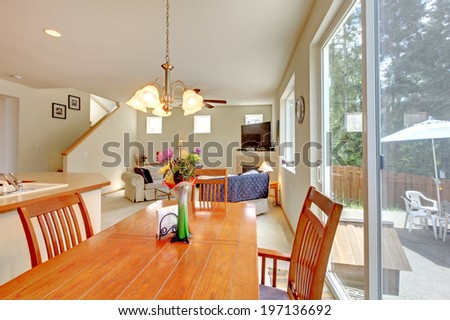 House interior with open floor plan. View of elegant dining table set decorated wtih red candles