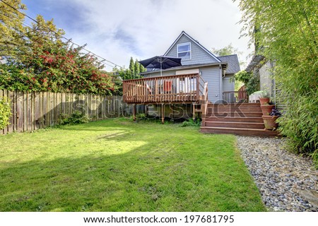 Small house with walkout deck to backyard, View of wooden deck with patio table set