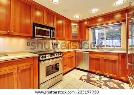 Shiny kitchen room with new storage combination and steel stainless appliances.