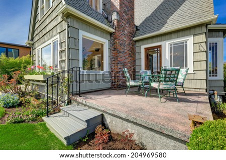 Small house with brick chimney. View of backyard walkout deck with patio table set