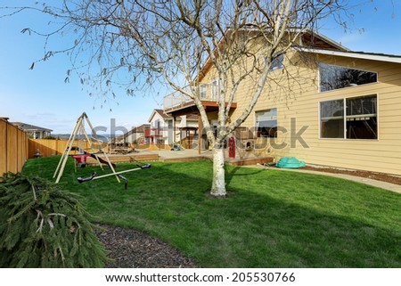 View of backyard with wooden walkout deck with patio area and kids playground