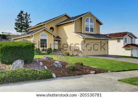Big ivory house with garage. View of front yard and walkway