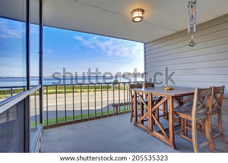 Small walkout deck overlooking driveway and bay. View of rustic table set