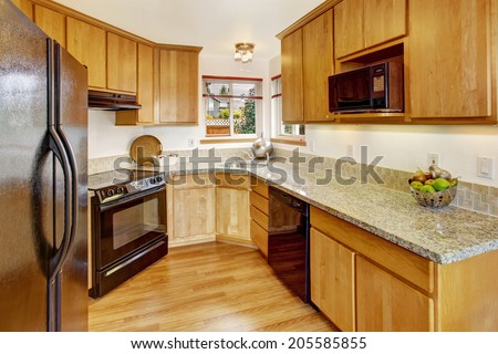 Bright small kitchen room interior with black appliances