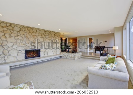 Bright living room with fountain in luxury house. View of fireplace built-in in rock wall