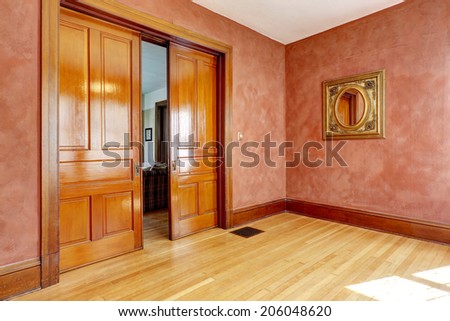 Empty bright red room with open slide door and antique mirror