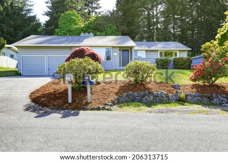 House exterior with landscape on front yard. View of garage and driveway
