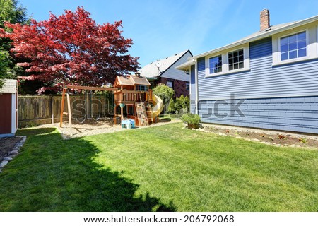 House backyard with lawn and playground for kids