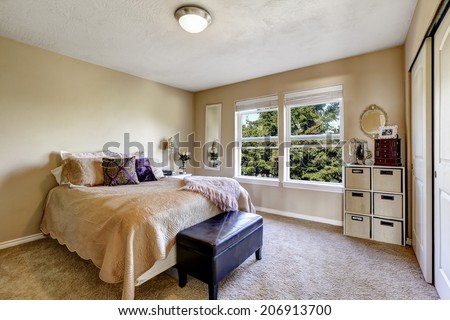 Simple bedroom interior with window. Furnished with bed, ottoman and storage unit