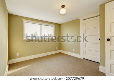 Small empty room with window and beige carpet floor