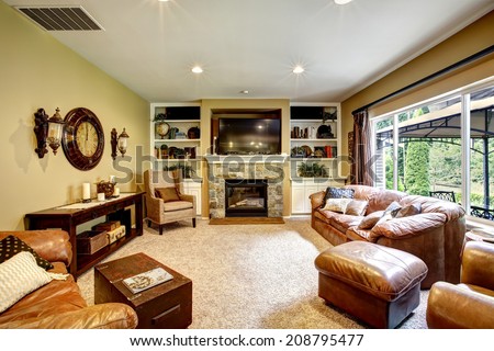 Living room interior with leather furniture set, stone fireplace and tv