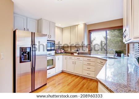 Elegant kitchen with white storage cabinets and granite tops