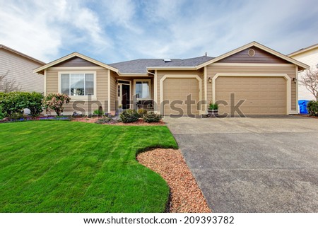House with curb appeal. View of entrance porch, garage with driveway and flower bed