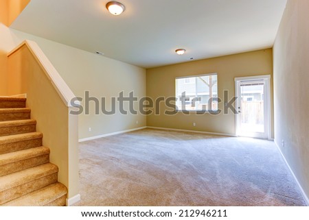 Living room with walkout deck and staircase. Empty house interior
