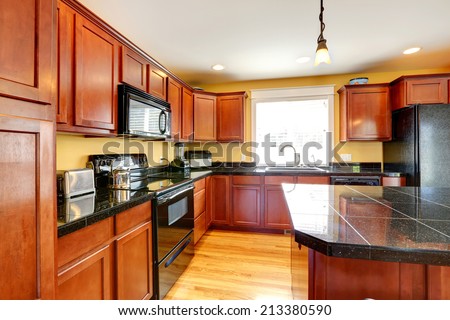 Kitchen room with black granite tops and black appliances
