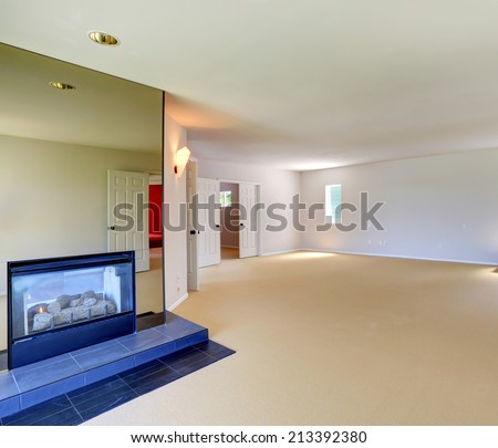 Bright empty room with soft creamy carpet floor and fireplace with mirror trim