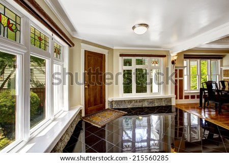 Luxury interior. Foyer with black shiny tile floor, large windows  with stone windowsill base trim