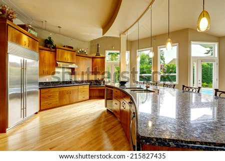Spacious luxury kitchen room with round kitchen island and black granite tops
