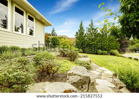 Ideas for front yard landscape design. Lawn with stone walkway and rocks