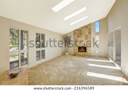 Floor plan in empty house. Beautiful living room with fireplace, vaulted ceiling and skylights