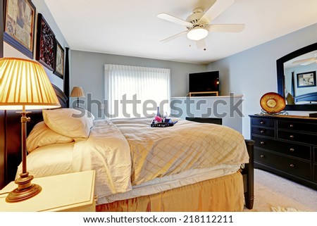 Light blue master bedroom with queen size bed and vanity cabinet