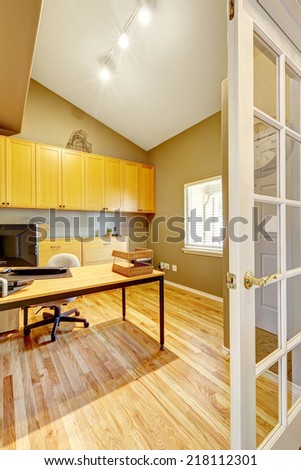 Practical office room design. White vaulted ceiling, beige wall and new hardwood floor.