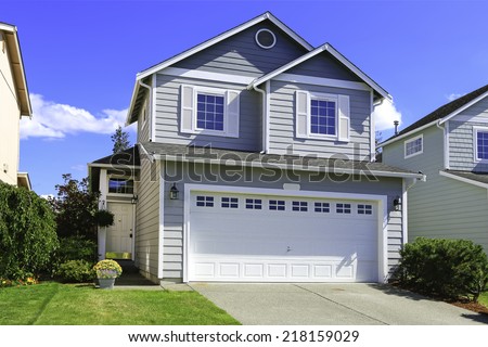 Two story house with small entrance porch and garage with driveway