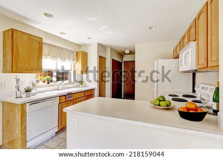 Simple kitchen interior in bright white color with wooden cabinets