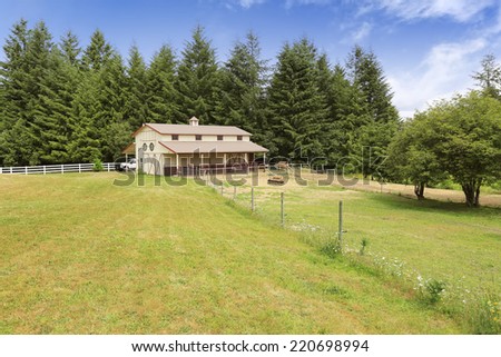 Large farm field with empty horse barn during summer in Olympia, Washington state