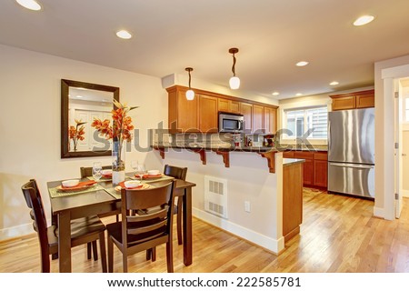 Cozy house interior. Kitchen room with wooden dining table decorated with fresh flowers