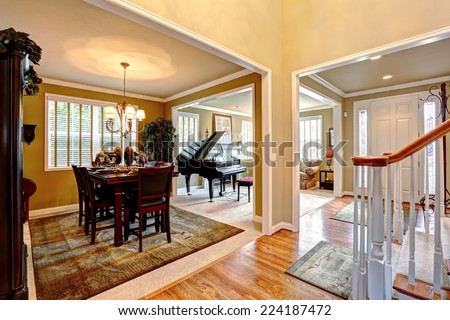 Luxury house interior with open floor plan. Dining area and living room with grand piano