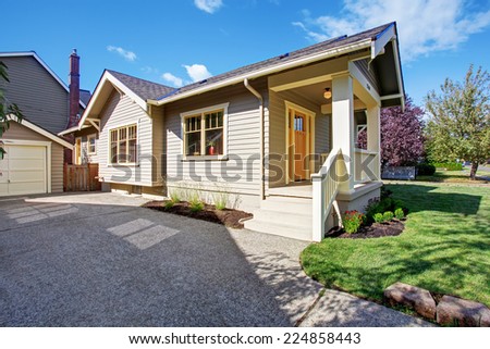 House exterior with garage and driveway. White entrance porch with railings and orange entrance door