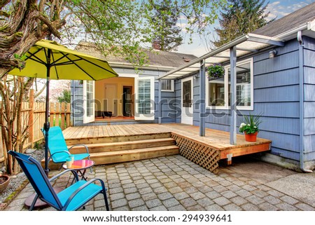Perfect back deck with concrete patio, umbrella, and chairs.