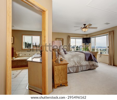 Large master bedroom with connected bathroom, and nice bedding.
