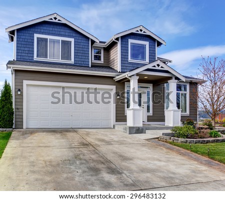 Large blue and gray home with white trim, also a driveway.