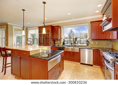 State of the art kitchen with stone tile floor and a tall island.