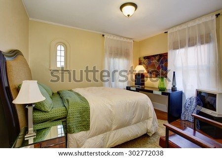 Well put together bedroom with hardwood floor, and green white bedding.
