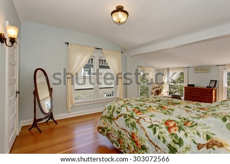 Large spring themed bedroom with tree decor bedding, and light blue walls.