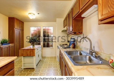 Traditional kitchen with tile floor, wood cabinets, and white interior paint.