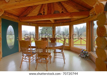 Log cabin breakfast area with dining room table and farm view